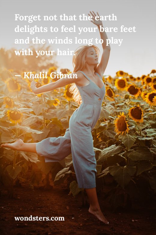woman jumping in front of sunflowers